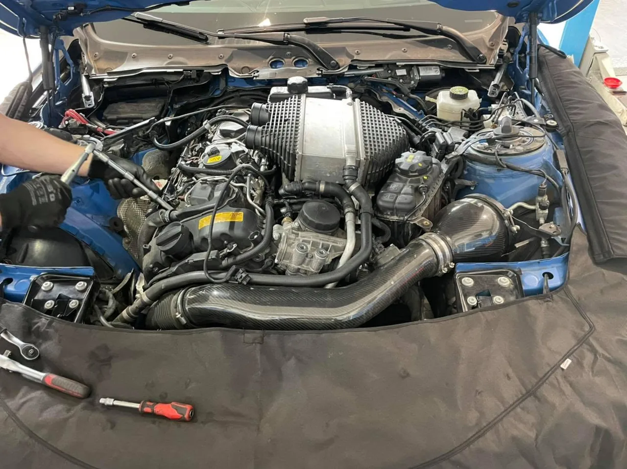 Mechanik pracuje na motoru s demontovanými kryty