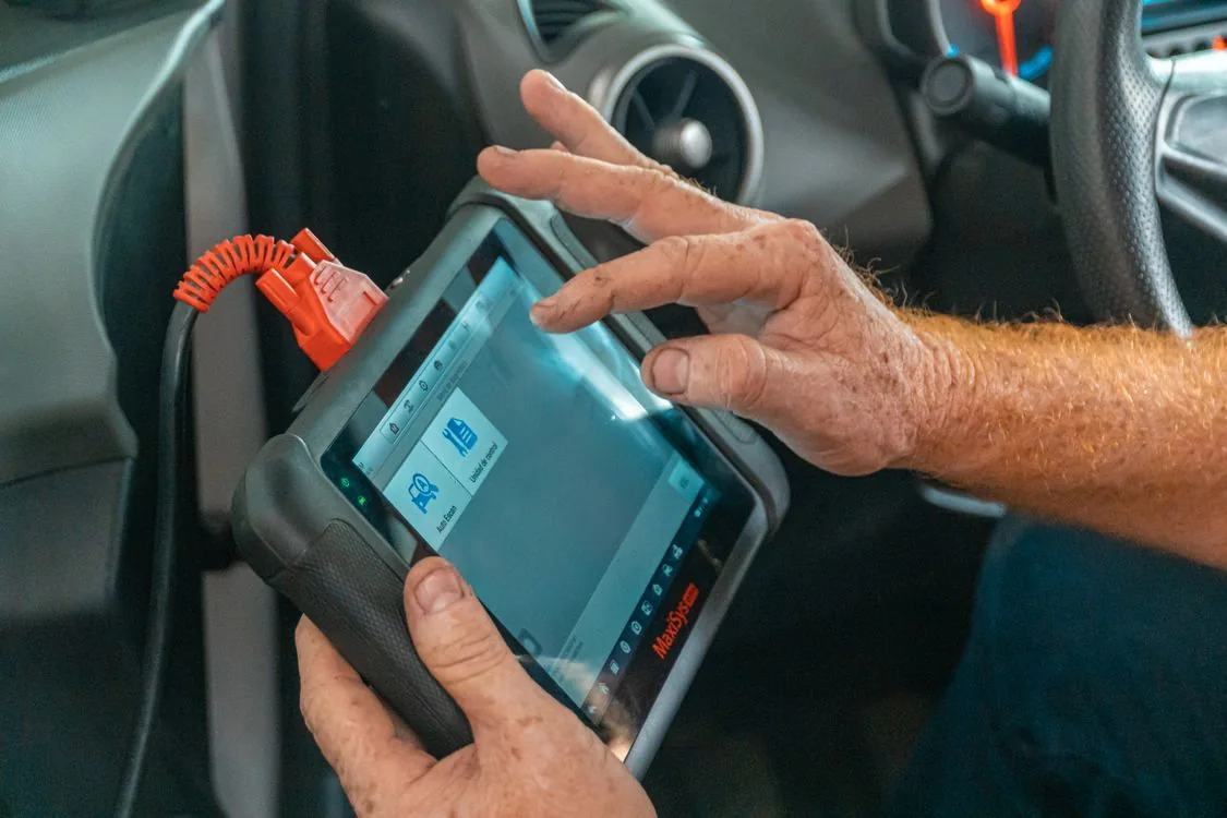 Mechanik používá diagnostický přístroj připojený k vozu