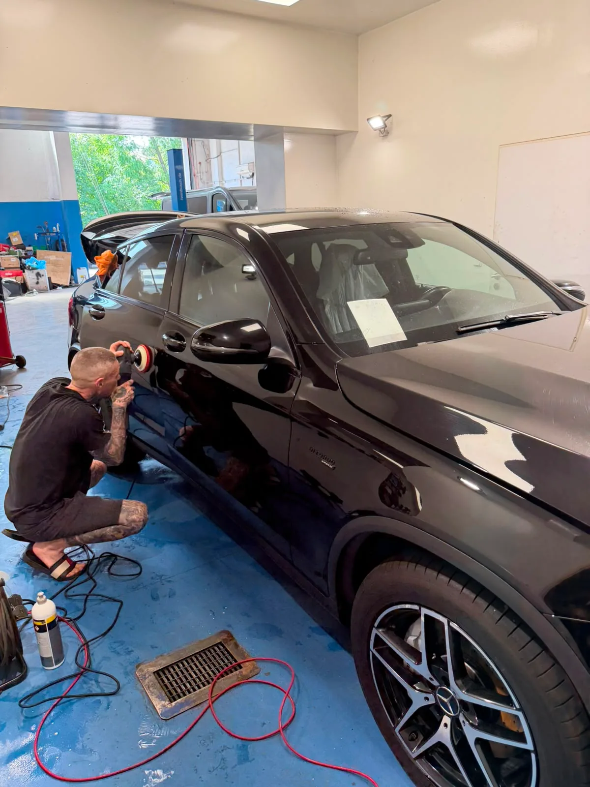 Leštění tmavého vozu v detailingové části dílny